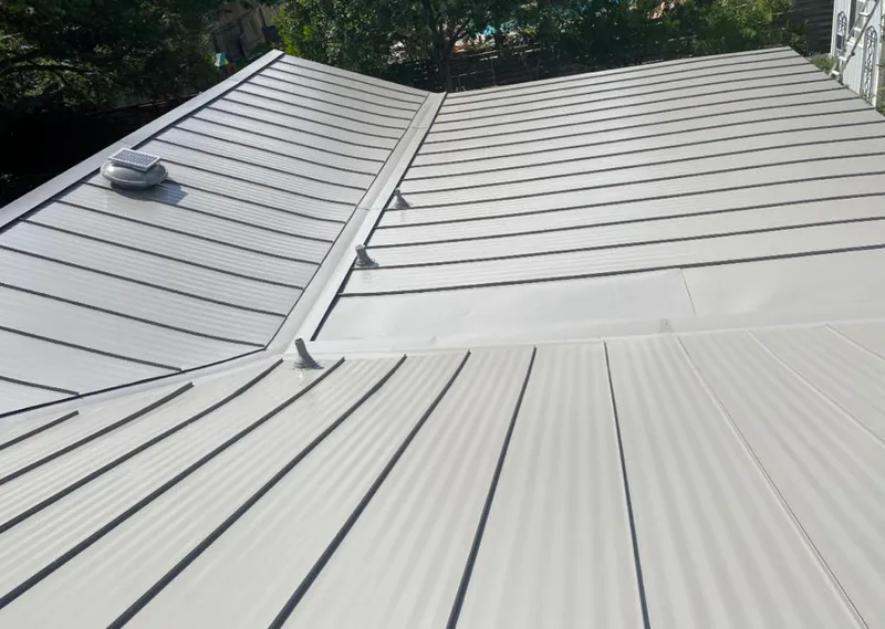Solar attic fan installed on a metal roof for Roof Ventilation in Estelle