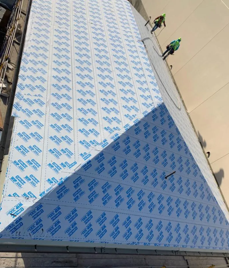 Professional roofers installing underlayment on a metal roof in Estelle